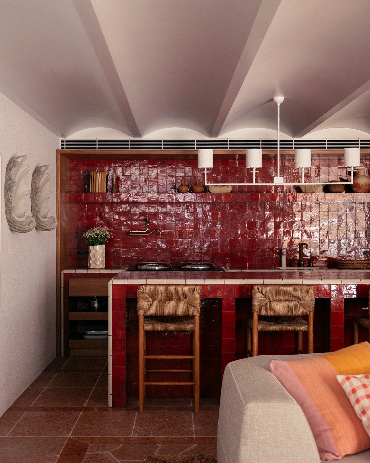 Glazed red-tiled kitchen with vaulted ceiling and rush-seat stools